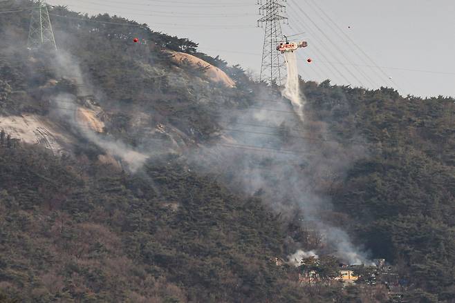 26일 오전 서울 노원구 수락산에서 산불이 발생해 소방헬기가 진화 작업을 벌이고 있다. [뉴시스]