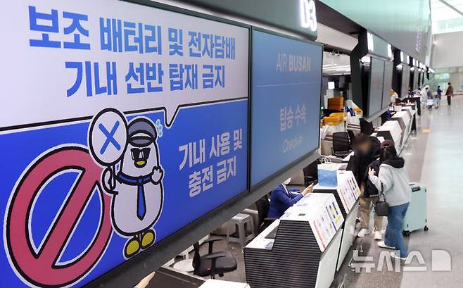 [부산=뉴시스] 하경민 기자 = 대한항공과 아시아나항공, 진에어, 에어부산, 에어서울 등이 기내에서 보조배터리 사용 전면 금지를 시작한 26일 부산 강서구 김해국제공항 국제선 에어부산 탑승수속대에서 보조배터리 기내 사용 금지를 안내하는 문구가 나오고 있다. 2026.01.26. yulnetphoto@newsis.com
