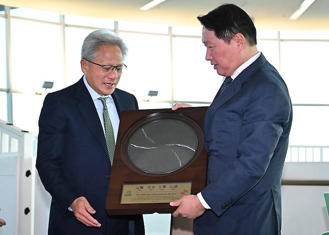 젠슨 황 엔비디아 CEO가 지난해 10월 31일 경북 경주시 경주예술의전당에서 열린 아시아태평양경제협력체(APEC) CEO 서밋에 참석해 최태원 SK그룹 회장 겸 대한상의 회장으로 부터 SK하이닉스의 HBM4 반도체 웨이퍼를 선물로 받고 있다.[사진 | 뉴시스]