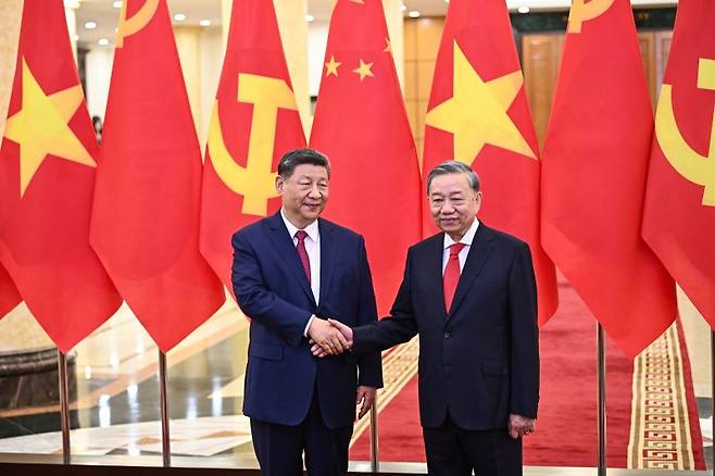 시진핑(왼쪽) 중국 국가 주석과 또 럼 베트남 공산당 서기장이 지난해 4월 14일(현지 시간) 베트남 하노이의 당 중앙위원회 청사에서 회담 전 악수하고 있다. 뉴시스