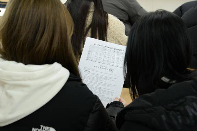 수험생들이 지난달 5일 울산 중구 다운고에서 2026학년도 수능 성적표를 확인하고 있다. 뉴시스