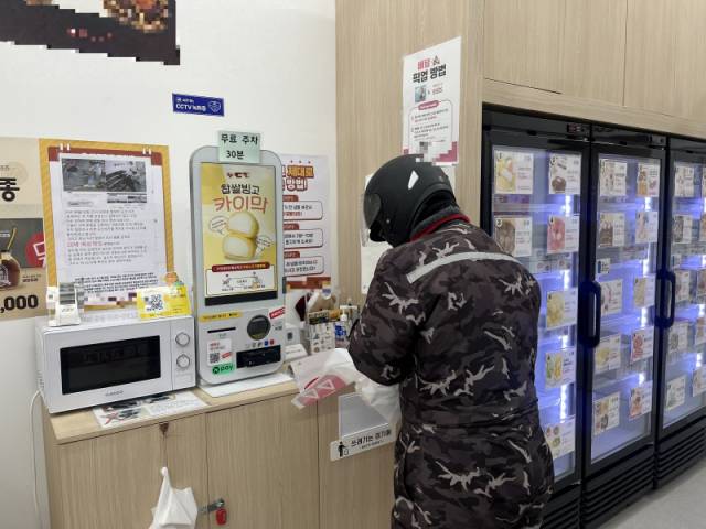 ▲ 26일 춘천의 한 무인 떡 매장에서 배달라이더가 배달할 떡을 직접 포장하고 있다.  최수현 기자