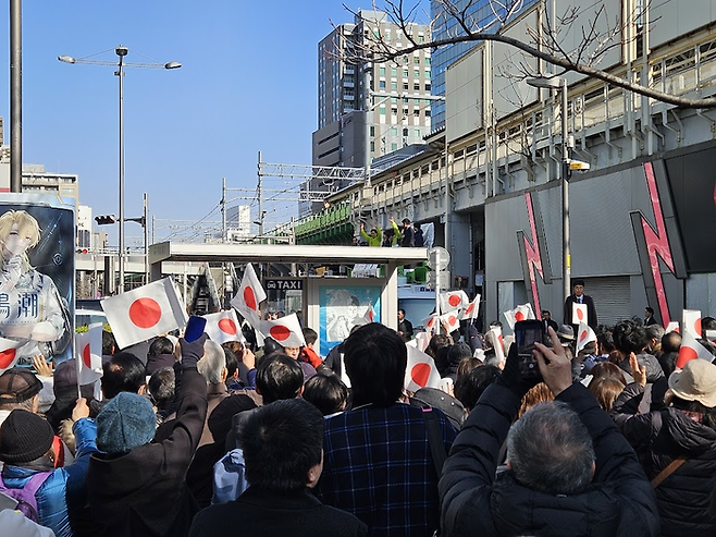 27일 도쿄 지요다구 아키하바라역에서 진행된 일본 중의원 선거유세에서 다카이치 사나에 일본 총리의 연설에 지지자들이 일장기를 흔들며 환호하고 있다. [도쿄 이승훈 특파원]