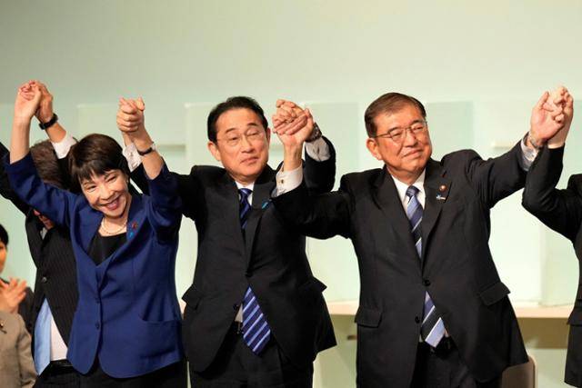기시다 후미오(가운데) 당시 일본 총리가 2024년 9월 27일 도쿄 자민당 당사에서 실시된 당 총재 선거에서 선출된 이시바 시게루(오른쪽) 후보와 경쟁한 다카이치 사나에 후보의 손을 들고 인사하고 있다. 도쿄=로이터 연합뉴스