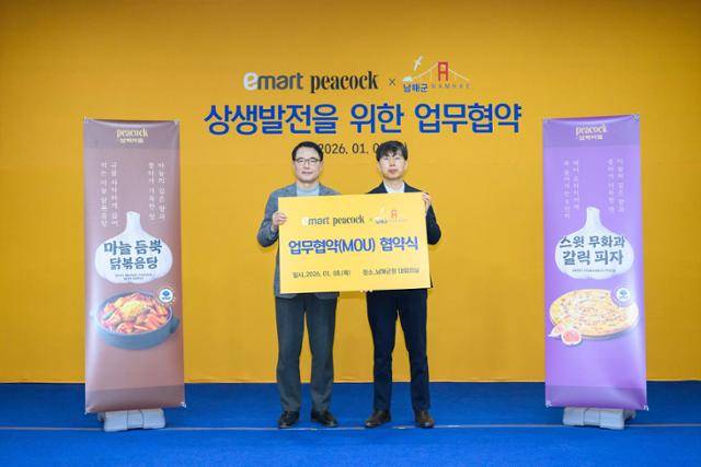 장충남(왼쪽) 군수가 8일 군청에서 이마트와 남해 마늘을 할용한 간편식 7종 개발 및 출시에 관한 업무협약을 체결한 뒤 기념촬영을 하고 있다. 남해군 제공