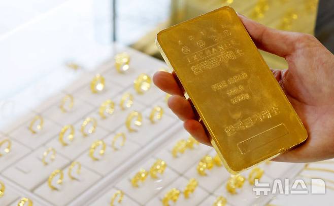[서울=뉴시스] 김혜진 기자 = 금값이 사상 처음으로 온스당 5100달러 선을 돌파한 27일 서울 종로구 한국금거래소 종로본점에서 한 시민이 골드바를 살펴보고 있다.26일(현지 시간) 파이낸셜타임스(FT), CNBC 등에 따르면 국제 금 현물 가격은 전장 대비 2.4% 오른 온스당 약 5102달러에 거래되며 최고치를 기록했다. 뉴욕상품거래소에서 2월 인도분 금 선물은 전 거래일보다 2.1% 오른 온스당 5082.50달러에 마감했다. 2026.01.27. jini@newsis.com
