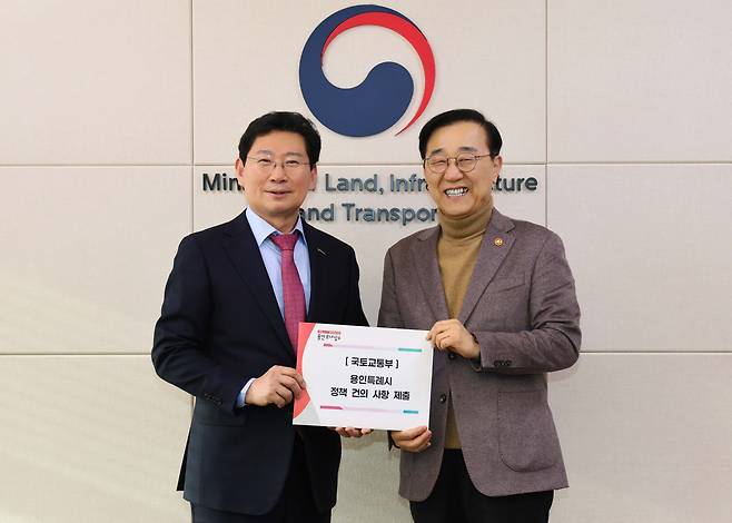 이상일(왼쪽) 용인특례시장이 26일 정부세종청사를 방문해 김윤덕 국토교통부 장관에게 '용인 첨단시스템반도체 클러스터 국가산업단지' 정상 추진과 '경기남부광역철도'의 제5차 국가철도망 구축계획 반영 등 7개 현안 사업 관련 건의문을 전달하고 있다. /용인시 제공