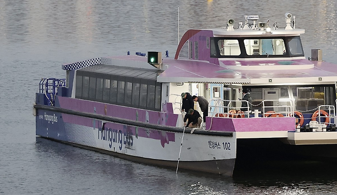 지난해 11월 16일 서울 송파구 잠실선착장 부근 강바닥에 걸려 멈춘 한강버스에서 관계자가 수심 확인을 하고 있다. 연합뉴스.