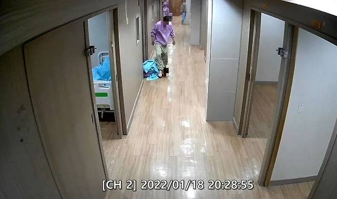 울산시 울주군 반구대병원 폐쇄병동 복도에서 한 환자가 누워있는 또 다른 환자의 머리를 발로 짓밟고 있다. [CCTV 캡처]