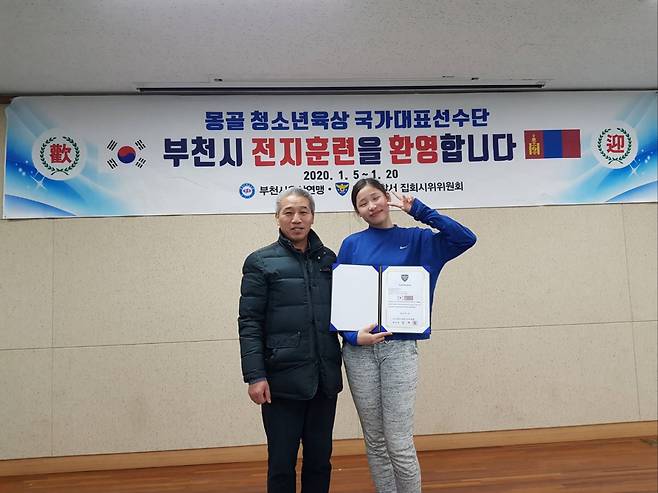 부천시육상연맹 노문선 회장(왼쪽)이 2020년 1월 몽골 육상 유망주 초청 전지훈련을 하면서 당시 멀리뛰기 선수로 방한한 인쿠시와 기념 사진을 찍고 있다.  부천시육상연맹 제공