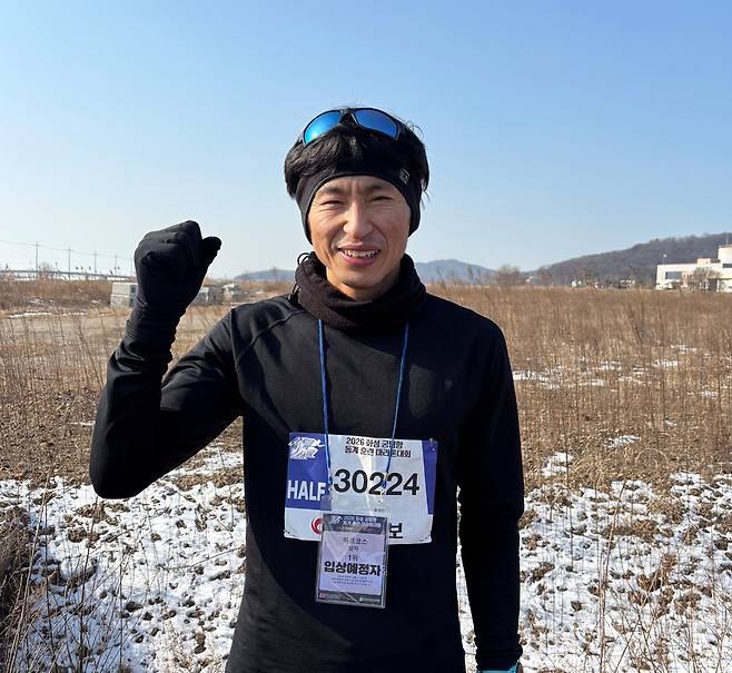 2026 화성 궁평항 동계훈련 마라톤대회 하프코스에서 남자부 1위에 오른 홍경민(평택·41) 씨가 기념 사진을 찍고 있다. <이세용 기자>