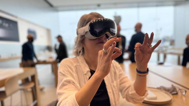 애플 비전프로를 착용한 채 손가락 제스처만으로 기기를 사용하고 있다./아이모어닷컴