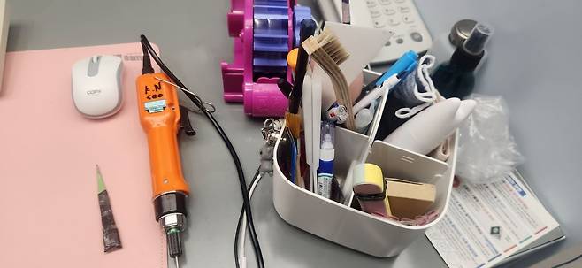 최씨의 책상에 놓인 수리 기구들. 핀셋, 전동드릴, 솔, 헤라 등이 가득 담겨있다. 백재연 기자