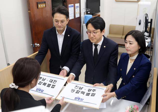 더불어민주당 천준호(가운데) 원내운영수석부대표, 전용기(왼쪽) 원내소통수석부대표, 백승아 원내대변인이 지난 30일 국회 의안과에 전남광주통합특별법안과 충남대전통합특별법안을 제출하고 있다.  <사진공동취재>