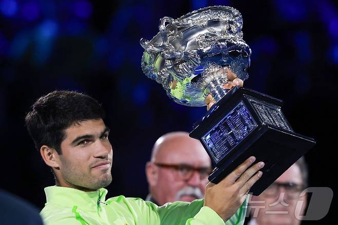 남자 테니스 세계 1위 카를로스 알카라스(스페인)가 1일 호주 멜버른에서 열린 호주오픈 테니스 대회 남자 단식 결승에서 우승컵인 노먼 브룩스 챌린지컵을 들어올리고 있다. ⓒ AFP=뉴스1
