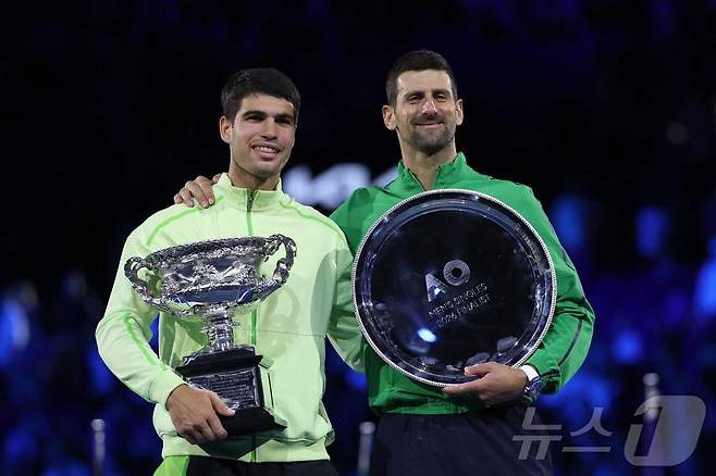 카를로스 알카라스(스페인)가 1일 호주 멜버른에서 열린 호주오픈 테니스 대회 남자 단식 결승에서 우승을 차지, 노박 조코비치(세르비아)와 시상대에 올라 기념 촬영을 하고 있다. ⓒ AFP=뉴스1
