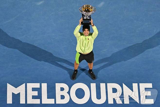 카를로스 알카라스(스페인)가 1일 호주 멜버른에서 열린 호주오픈 테니스 대회 남자 단식 결승에서 우승컵인 노먼 브룩스 챌린지컵을 들어올리고 있다. ⓒ AFP=뉴스1