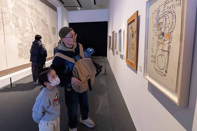 바스키아는 줄곧 끼적였다. 미술가로 활동한 8년간 3700여점을 남길 수 있었던 이유다. 정식 미술 교육을 받지 않았지만, 그래서 더 빛나는 바스키아의 드로잉은 아이들에게 영감을 줬다. 31일 아빠와 전시장을 찾은 어린이. 전민규 기자