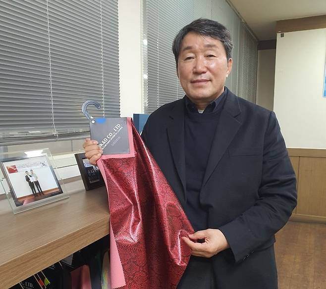 최민석 대표가 의류용 원단을 들어보이고 있다. 안산=윤현주 기자