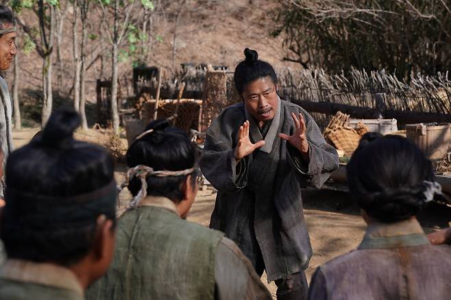 <왕과 사는 남자>의 강원도 영월 광천골 촌장 엄흥도(유해진)가 마을 사람들에게 무언가를 설명하고 있다. 쇼박스 제공