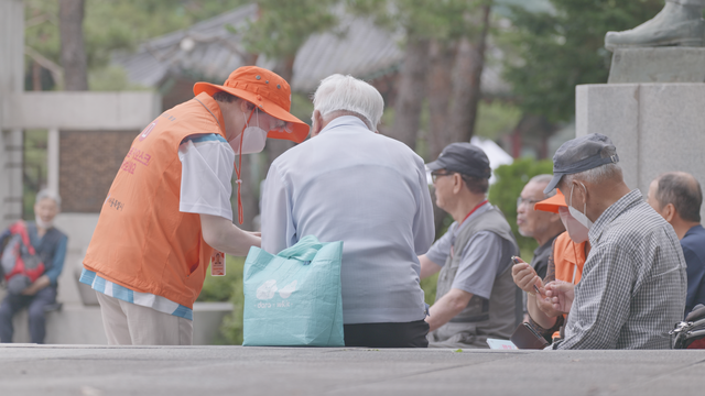 ‘디지털 안내사’가 디지털 기기 사용에 어려움을 겪는 시민에게 스마트폰 활용 방법을 안내하고 있다. 서울시청 제공
