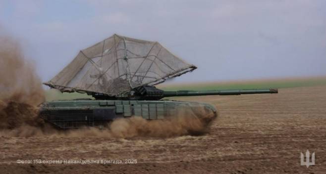 우크라이나군 제153독립기계화여단에서 운용 중인 드론 방어용 “후드”를 장착한 T-72EA 전차.