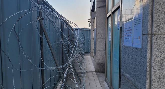 ▲ 철재 담장과 건물 현관 사이에 접근을 막는 철조망이 쳐져 있다. /인천일보DB