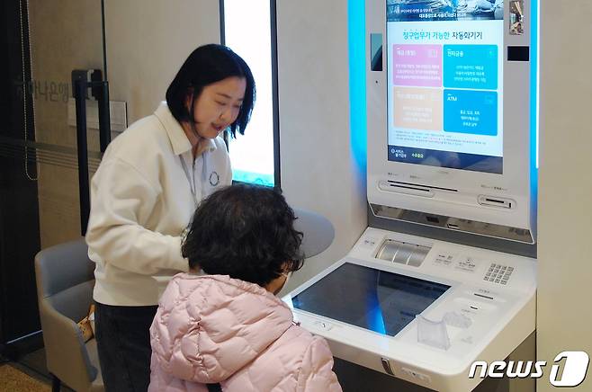 하나은행은 중∙장년층 손님들의 업무 편의성 향상과 차별화된 공간을 제공하기 위해 ‘시니어 특화점포’를 신설했다고 16일 밝혔다. STM (Smart Teller Machine, 지능형 자동화 기기) 전담 매니저를 배치하여 중∙장년층 손님의 기기 이용을 지원하고 있다. (하나은행 제공) 2024.2.16/뉴스1