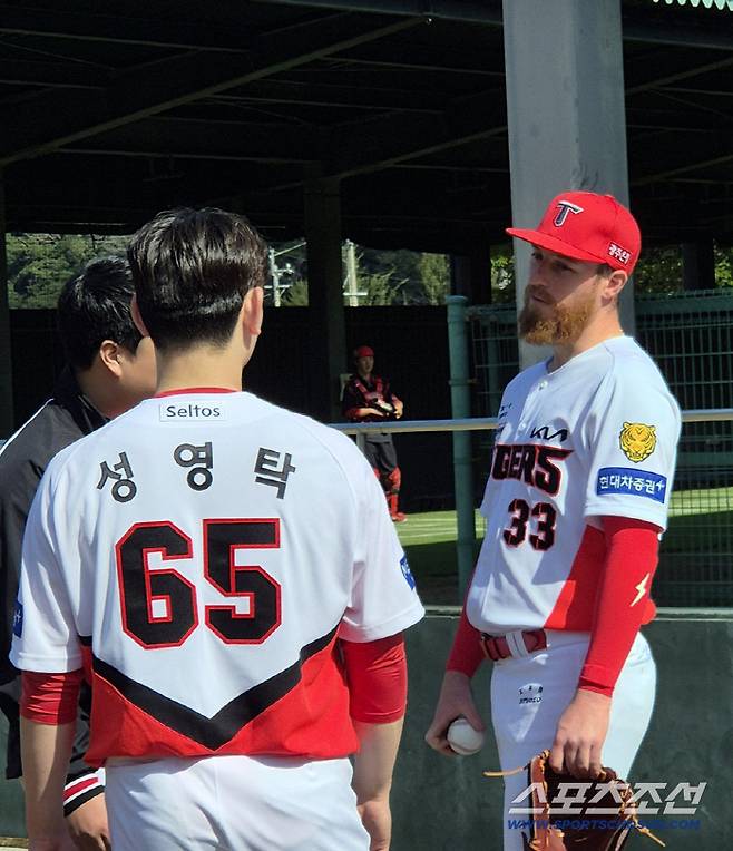 KIA 타이거즈 성영탁(왼쪽)이 아담 올러와 불펜 피칭을 마친 뒤 대화를 나누고 있다. 아마미오시마(일본)=김민경 기자