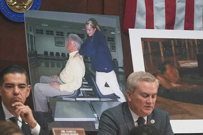 미국 공화당 소속 제임스 코머 하원 감독위원회 위원장이 지난달 21일 워싱턴 국회의사당에서 클린턴 부부에 대한 의회 모독 혐의 처벌 여부에 관한 발언을 하고 있다. 그 뒤로는 엡스틴 사건 파일에서 공개된 빌 클린턴 전 대통령이 젊은 여성과 함께하고 있는 사진이 보인다. AP 연합뉴스