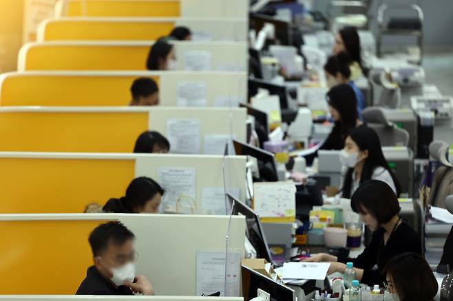 Customers interact at a KB Kookmin Bank branch in Yeouido, western Seoul, on March 27, 2023. [YONHAP]