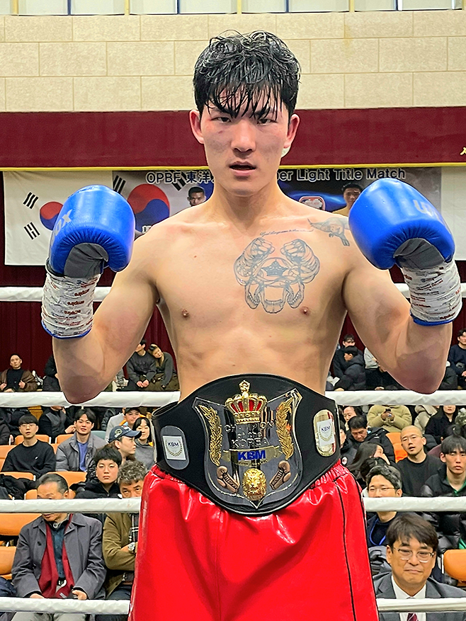 세계복싱평의회 아시아 실버 타이틀매치 출신 장인수가 2026년 1월 서울특별시 이태원초등학교 특설 링에서 사단법인 한국복싱커미션 슈퍼밴텀급 챔피언 등극 기념 촬영을 하고 있다. 오른쪽 아래는 황현철 SBS 스포츠 및 tvN SPORTS 해설위원. 사진=KBM