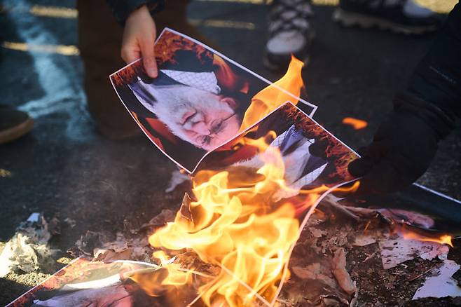 [토론토=AP/뉴시스] 지난 1일(현지 시간) 캐나다 온타리오주 토론토에서 이란 정권 교체를 지지하는 시위대가 아야톨라 알리 하메네이 이란 최고지도자 사진을 불 태우고 있다. 2026.02.04.