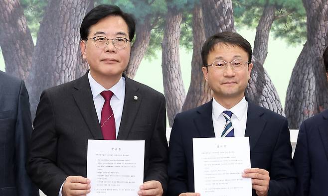 한병도 더불어민주당 원내대표와 송언석 국민의힘 원내대표가 4일 서울 여의도 국회에서 미국의 관세 재인상과 관련해 대미투자특별법 처리를 위한 특별위원회를 구성하기로 합의 후 합의문을 들고 기념촬영하고 있다. 뉴스1