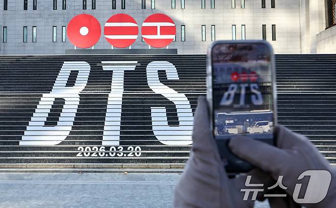 서울 종로구 세종문화회관 계단에 설치된 방탄소년단(BTS)의 정규 5집 컴백을 알리는 홍보물을 배경으로 관광객들이 기념촬영을 하고 있다. 2026.1.22/뉴스1 ⓒ News1 최지환 기자