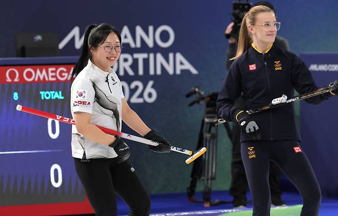 컬링 믹스더블 국가대표 김선영이 정전 사고로 경기가 중단되자 상대 스웨덴 선수인 이사벨라 브라노와 함께 브룸을 들고 기타를 치는 동작을 하고 있다. 사진 | 코르티나=연합뉴스