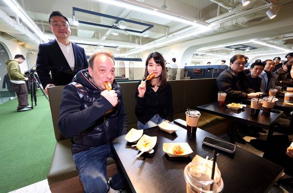 다니엘 산체스와 용현지가 5일 서울 논현동 ‘PBA 라운지 1호점’ 개소식에서 핫도그를 먹고 있다. PBA 제공