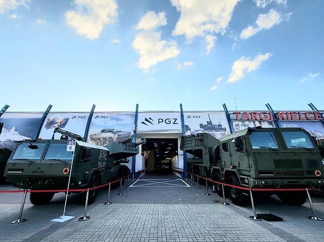 2023년 10월 폴란드 키엘체에서 열린 MSPO 방산전시회 입구 앞에 전시된 폴란드형 천무 호마르-K(오른쪽)와 대표적인 글로벌 다연장 무기체계인 미국의 하이마스 폴란드형(왼쪽)이 전시돼 있는 모습. 사진 한화에어로스페이스