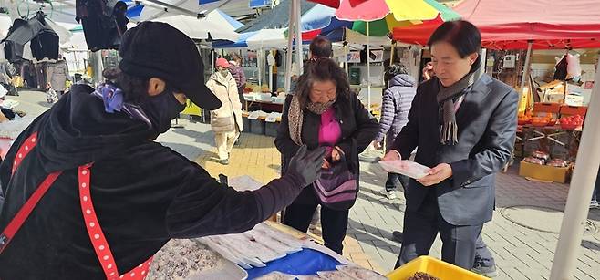 4일 이승익 고령관광재단 대표가 고령전통시장에서 찹쌀떡을 구입하고 있다. <석현철 기자>