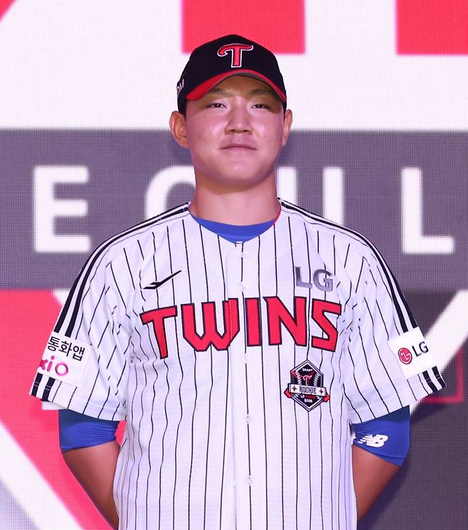 양우진이 지난 17일 열린 2026 신인 드래프트에서 전체 8순위 지명을 받은 뒤 LG 유니폼을 입고 활짝 웃고 있다. 구단 제공