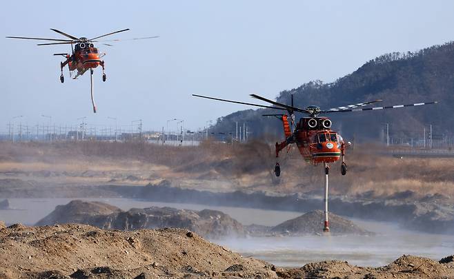 7일 오후 9시 40분께 발생한 경주시 문무대왕면 입천리 일원의 산불이 이틀째 이어지는 가운데 8일 오후 진화작업에 투입된 산불 진화 헬기가 대종천에서 물을 담고 있다. /이용선기자 photokid@kbmaeil.com