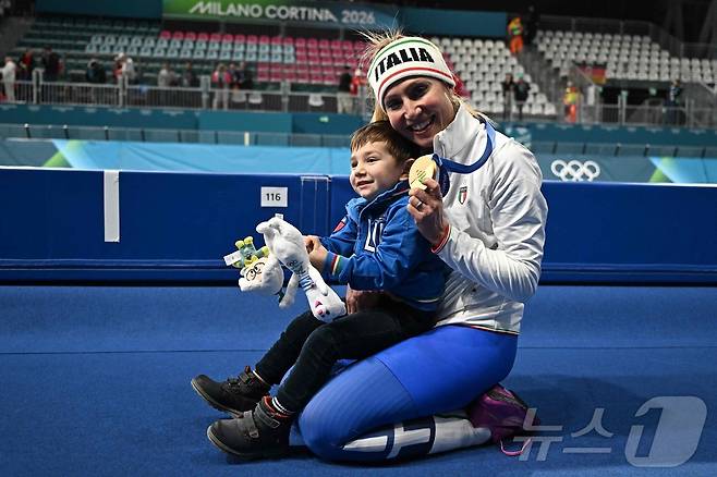 프란체스카 롤로브리지다(이탈리아)가 8일(한국시간) 열린 2026 밀라노 코르티나 동계 올림픽 스피드스케이팅 여자 3000m에서 금메달을 딴 뒤 아들 토마소와 함께 기뻐하고 있다. ⓒ AFP=뉴스1