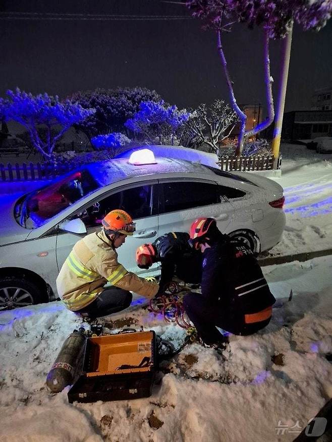 지난 7일 오후 11시 47분쯤 전남 나주시 산포면의 한 도로에서 택시가 눈길에 고립돼 소방당국이 안전조치하고 있다. (전남소방본부 제공. 재판매 및 DB 금지)