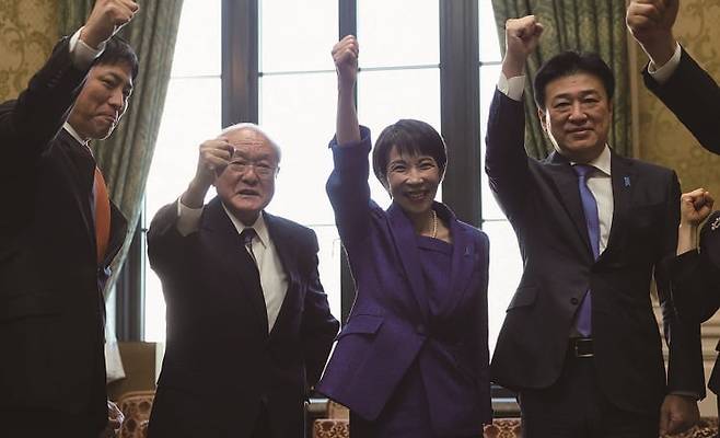 다카이치 사나에(왼쪽에서 세번째) 일본 총리가 당 소속 의원들과 함께 주먹을 들어 올리며 "간바로(힘내자)"를 외치고 있다. /로이터 연합뉴스