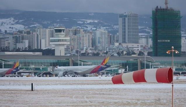 7~8일 제주국제공항에 많은 눈이 내려 제설작업으로 공항 운영이 오전 한때 중단됐다. 사진은 제주공항 활주로에 강한 바람이 불고 눈이 쌓여 있는 모습. 연합뉴스