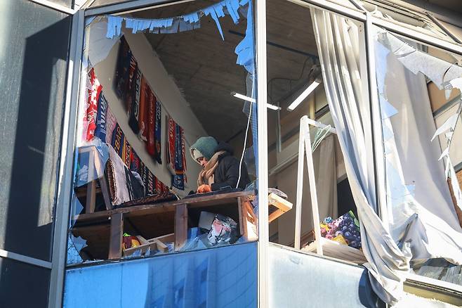 9일(현지 시각) 러시아의 드론 공격을 받은 우크라이나 오데사의 한 건물에서 한 여성이 깨진 유리창 사이로 모습을 나타냈다./로이터연합뉴스