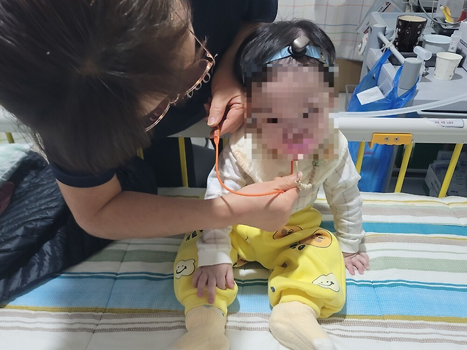 4일 양미영 간병인이 기관절개관(인공 기도)을 통해 가래를 빼내고 있다. 김하늘(가명) 군은 선천적으로 기도식도누공(숨을 쉬는 기관과 음식이 지나가는 식도 사이가 비정상적으로 연결된 질환)을 갖고 있어 기관식도샛길 수술을 했다. 영양공급은 위루관을 통해 이뤄진다. 태어날 때부터 한쪽 귀가 없어 머리띠형 보청기를 착용해야 한다. 이설화 기자