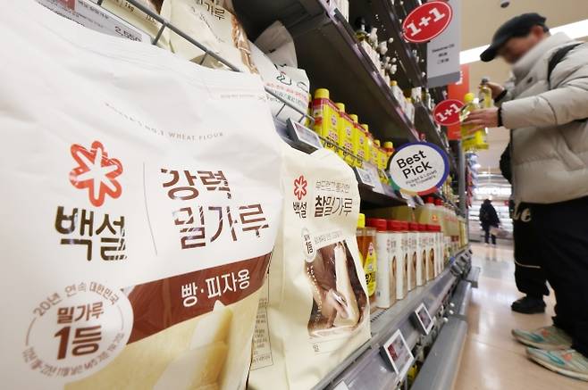 줄줄이 인하된 밀가루·설탕값 - 이재명 대통령이 지난 5일 검찰의 ‘밀가루·설탕 업체 담합 적발’을 거론하며 독과점에 따른 고물가 촉발을 강조하자 곧바로 CJ제일제당, 삼양사, 사조동아원 등이 이들 물품의 가격 인하를 발표한 가운데 8일 서울의 한 대형마트 밀가루 판매대 인근에서 한 소비자가 물건을 고르고 있다. 연합뉴스