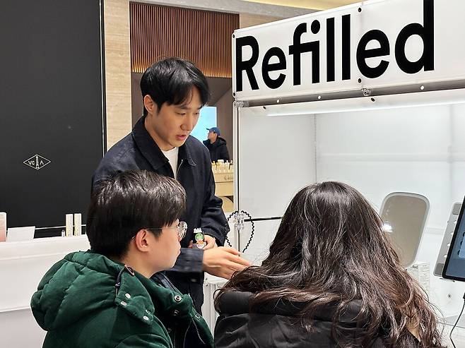 리필드 현대백화점 판교점 팝업스토어에서 AI 두피스캐너를 소개하며 탈모 고객의 두피 상태를 설명 중인 정근식 콘스탄트 대표./콘스탄트