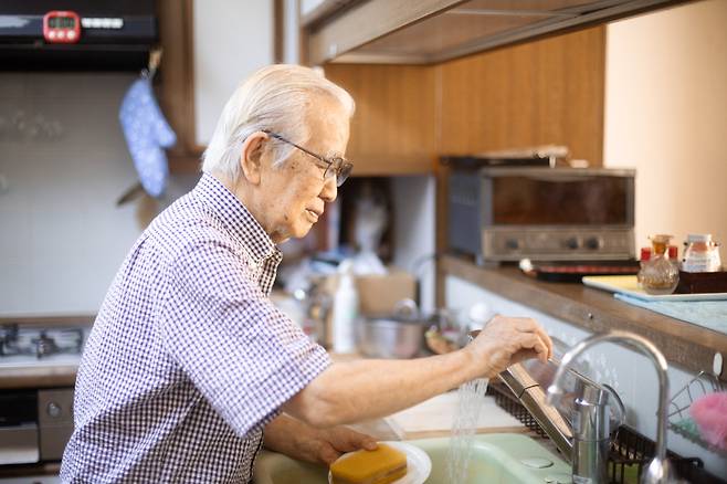 주방에서 홀로 요리를 준비하는 작가 아토다 다카시. 일상의 모든 일을 아내 없이 혼자 해내는 '자취' 생활이 이젠 익숙해졌다고 했다. (신초샤(新潮社) 제공, ©Shinchosha)